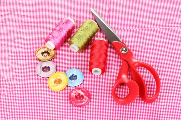 Scissors, buttons and bright threads on fabric isolated on white — Stock Photo, Image