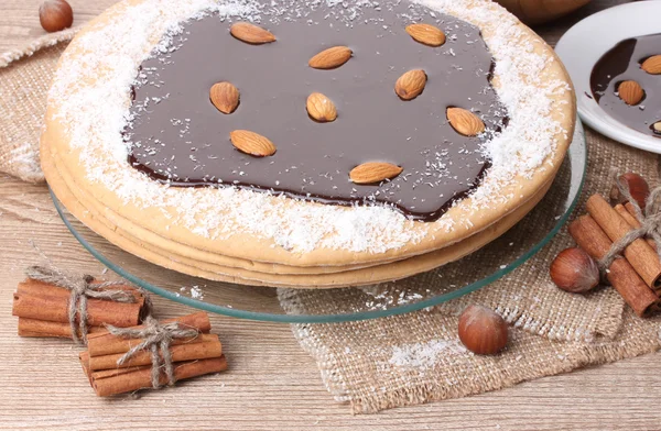 Торт на стеклянном стенде и орехи на деревянном столе — стоковое фото