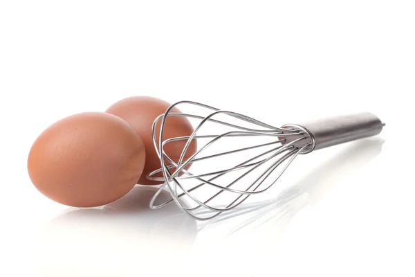 Metallbesen zum Aufschlagen von Eiern und braunen Eiern isoliert auf weiß — Stockfoto