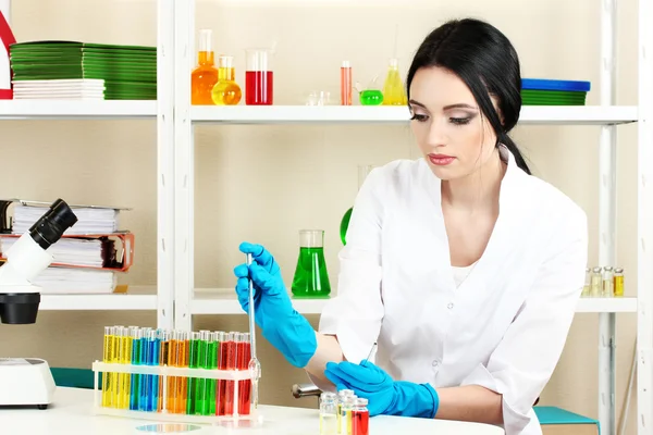 Молодая женщина-ученый ищет в лаборатории химии — стоковое фото