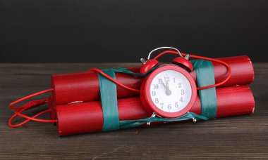 Timebomb made of dynamite on wooden table on grey background clipart