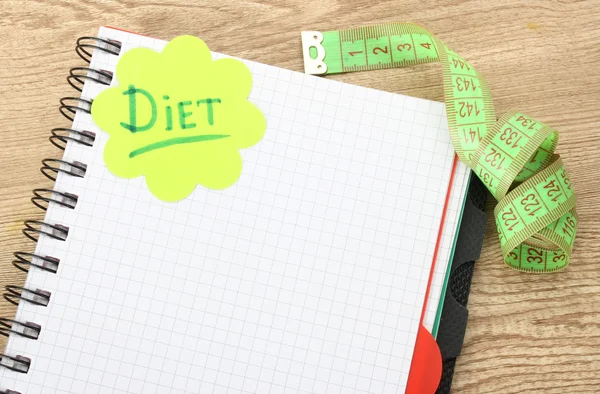 Planning van dieet. laptop meten tape en pen op houten tafel — Stockfoto