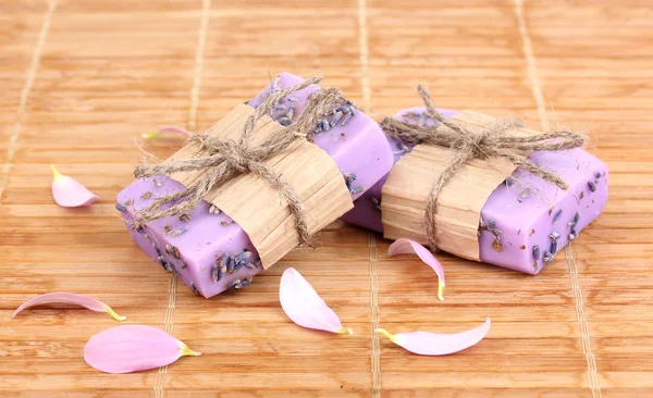 Hand-made lavender soaps on wooden mat — Stock Photo, Image