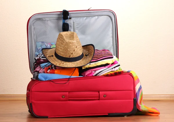 Maleta roja abierta con ropa en la habitación — Foto de Stock