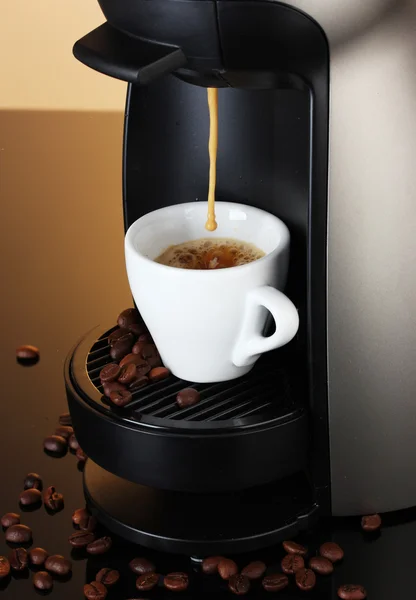 stock image Espresso machine pouring coffee in cup on brown background