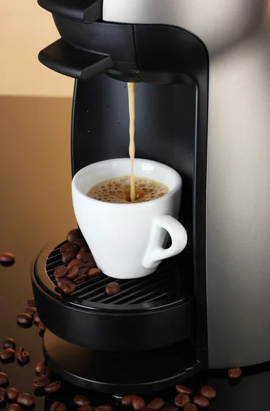 stock image Espresso machine pouring coffee in cup on brown background