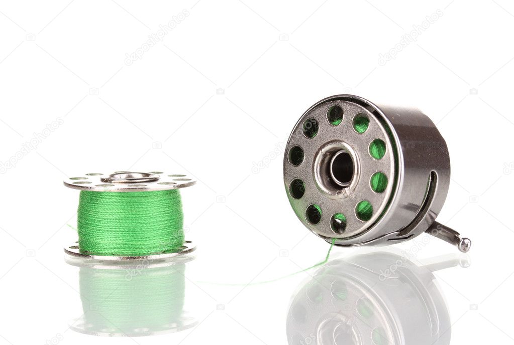 Metal spool of thread and sewing machine shuttle isolated on white