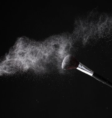 make-up borstel met poeder geïsoleerd op zwart
