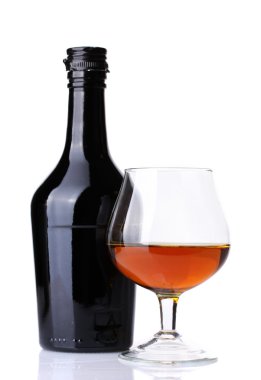 Glass of brandy and bottle isolated on white clipart