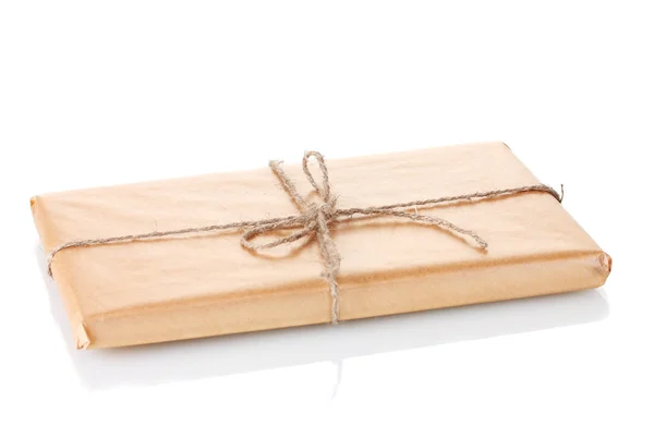 Parcel wrapped in brown paper tied with twine isolated on white — Stock Photo, Image