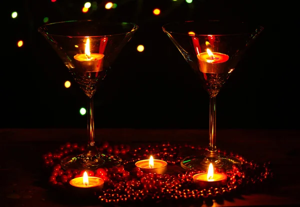 Increíble composición de velas y vasos sobre mesa de madera sobre fondo brillante — Foto de Stock