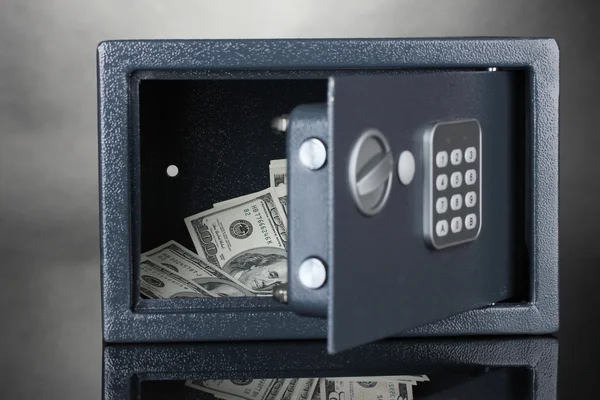 Safe mit Dollars auf grauem Hintergrund — Stockfoto