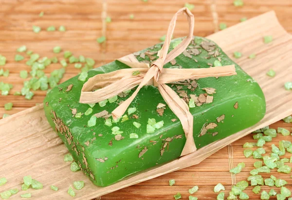 Hand-made herbal soap on wooden mat — Stock Photo, Image