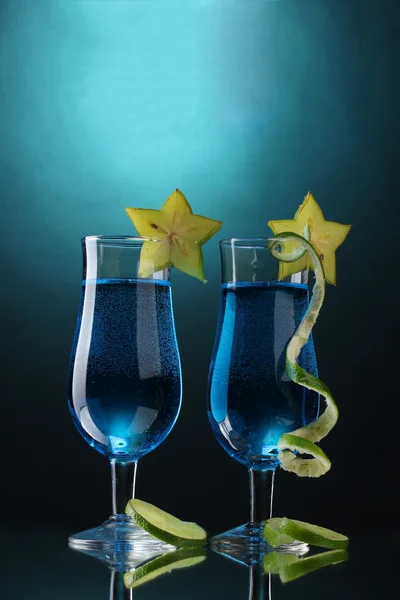 Синий коктейль в очках на синем фоне — стоковое фото