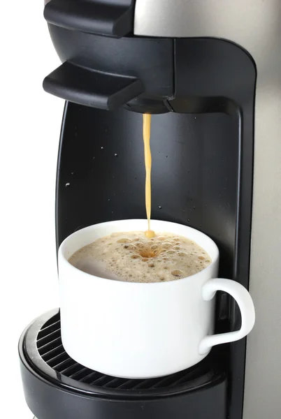 Еспресо-машина наливає каву в чашку ізольовану на білому — стокове фото