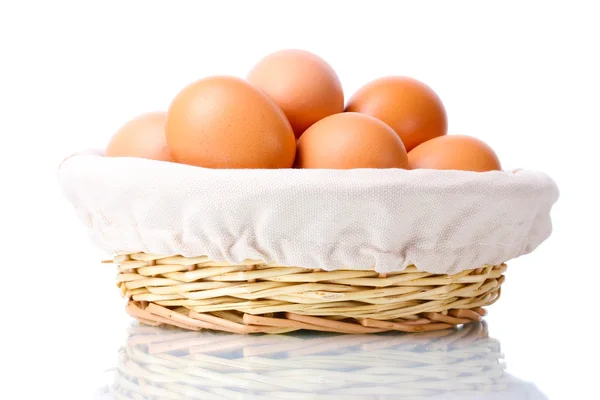 Hnědá vejce v košíku izolovaných na bílém — Stock fotografie