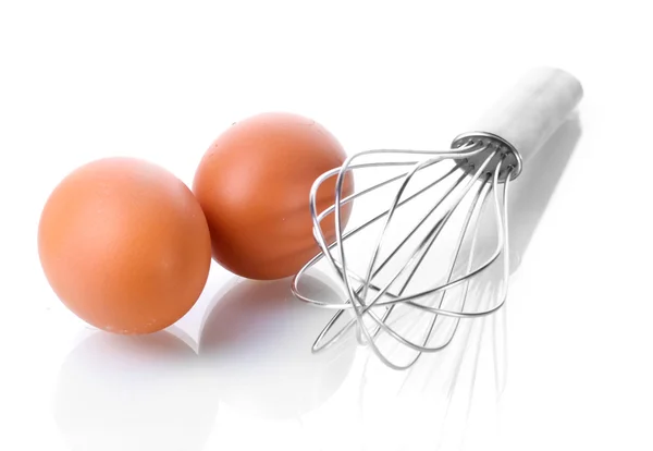 Frusta metallica per montare uova e uova marroni isolate su bianco — Foto Stock