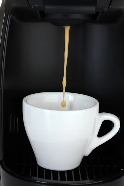 Эспрессо-машина наливает кофе в белую чашку — стоковое фото