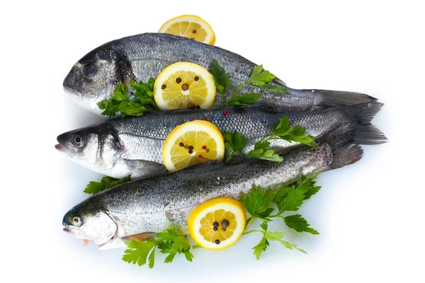 stock image Fresh fishes with lemon, parsley and spice isolated on white