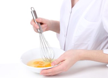 Female hands Mixing eggs in bowl isolated on white clipart