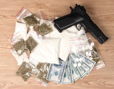 kokain ve esrar ve paketleri, dolar ve ahşap zemin üzerinde tabanca