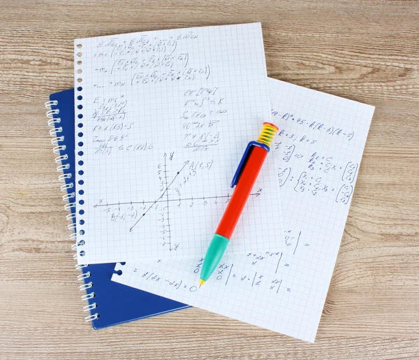 Math, physics and geometry on copybook page on a wooden table — Stock Photo, Image