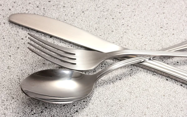 Forchetta, cucchiaio e coltello sul tavolo di marmo — Foto Stock