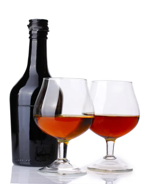 Okulary z brandy i butelka na białym tle — Zdjęcie stockowe