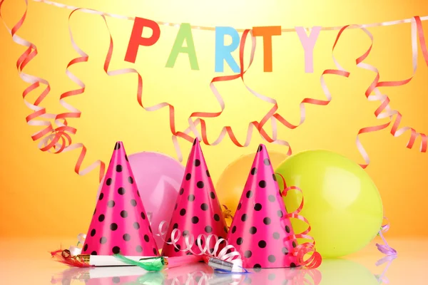 Partyartikel auf orangefarbenem Hintergrund — Stockfoto