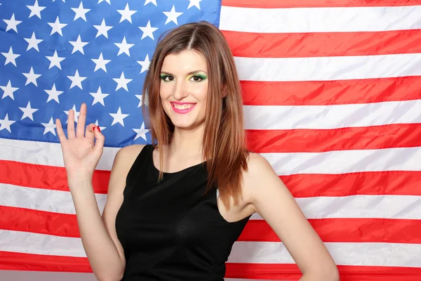 백그라운드에 미국 국기와 함께 아름 다운 젊은 여자 — 스톡 사진