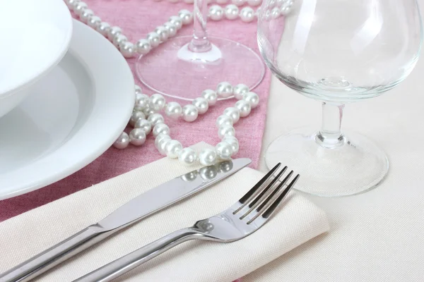 Table setting with fork, knife, plates, beads and napkin — Stock Photo, Image