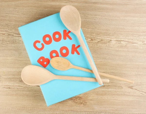 Kuchařka a nádobí na dřevěné pozadí — Stock fotografie