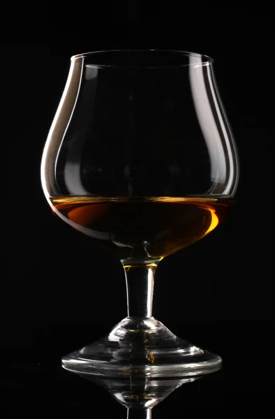 Glass of cognac on black background — Stock Photo, Image