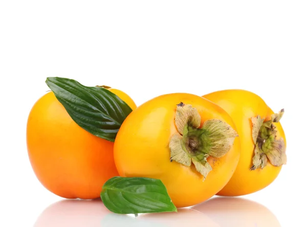 Tre aptitretande sharonfrukt med gröna blad isolerad på vit — Stockfoto