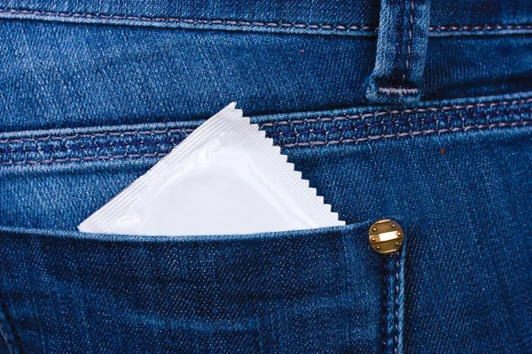 Презерватив в кармане синих джинсов — стоковое фото