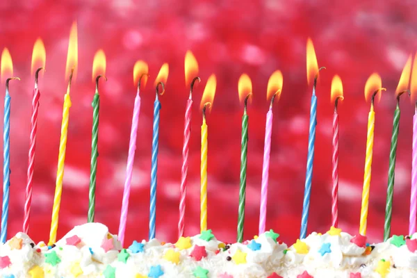 Schöne Geburtstagskerzen auf rotem Hintergrund — Stockfoto