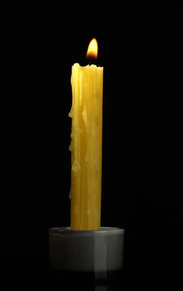 Желтая свеча на черном фоне — стоковое фото