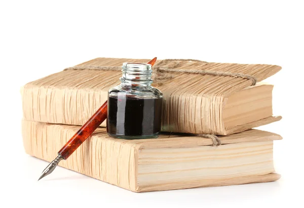 Libros antiguos, pluma de tinta y botella de tinta aislados en blanco Imagen de stock