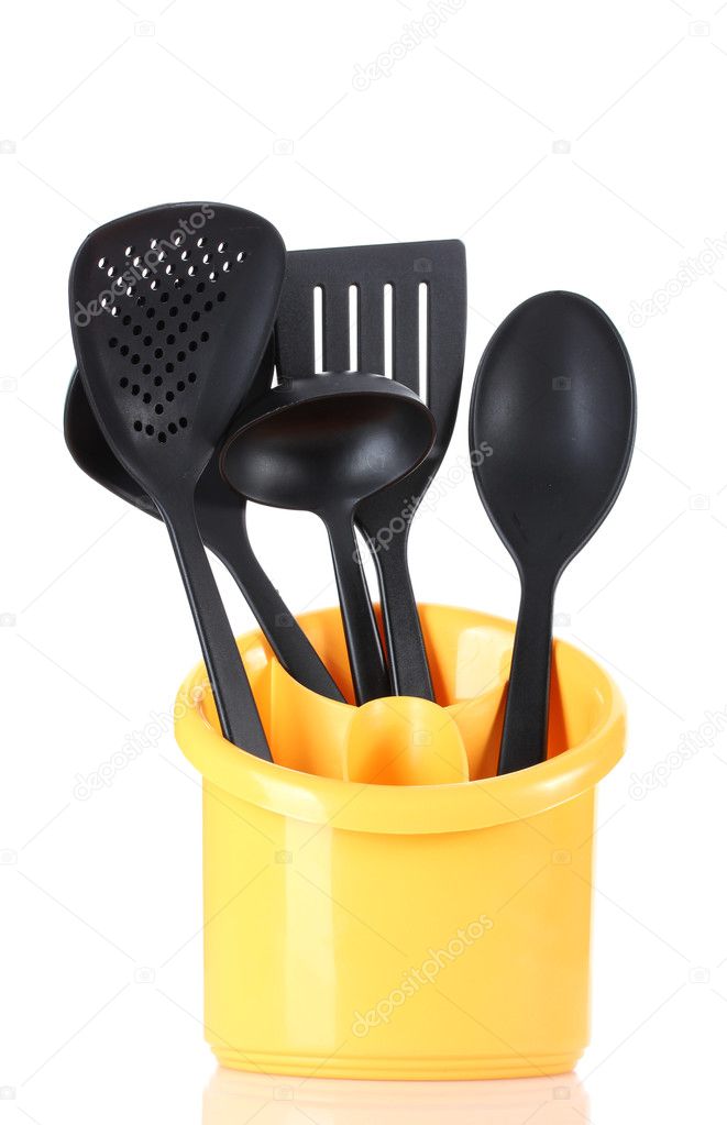 Black kitchen utensils in yellow stand isolated on white