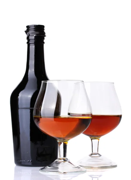 Vasos de brandy y botella aislados en blanco — Foto de Stock