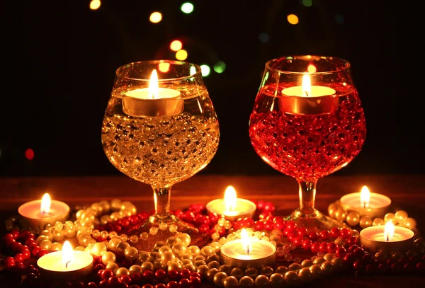 Καταπληκτική σύνθεση κεριών και γυαλιά στο ξύλινο τραπέζι σε φωτεινό φόντο — Φωτογραφία Αρχείου