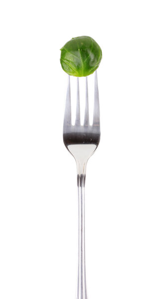 Fresh brussels sprout on fork isolated on white
