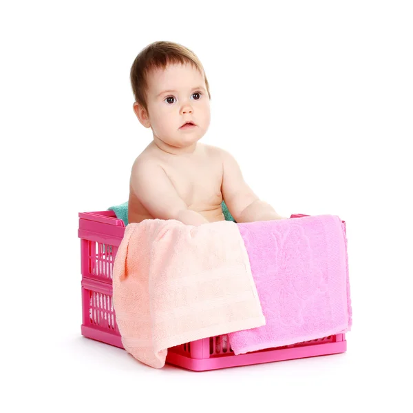 Söt baby flicka sitter i tvättkorg isolerad på vit — Stockfoto