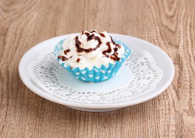 ahşap zemin üzerinde uçan daire üzerinde kremalı cupcake