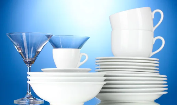 Cuencos vacíos, platos, tazas y vasos sobre fondo azul —  Fotos de Stock