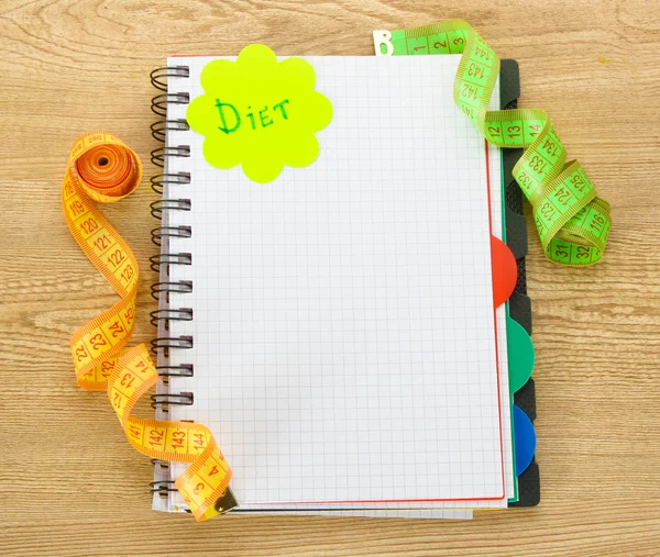 Planejamento da dieta. Caderno de fitas de medição e caneta em mesa de madeira — Fotografia de Stock