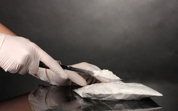 Paket kokain öppning med en kniv på grå bakgrund — Stockfoto
