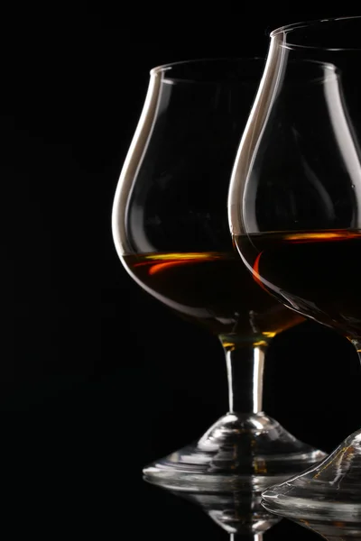 Twee glazen van cognac op zwarte achtergrond — Stockfoto