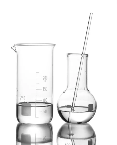 Béquer de medição e frasco com água e com reflexão isolada sobre branco — Fotografia de Stock