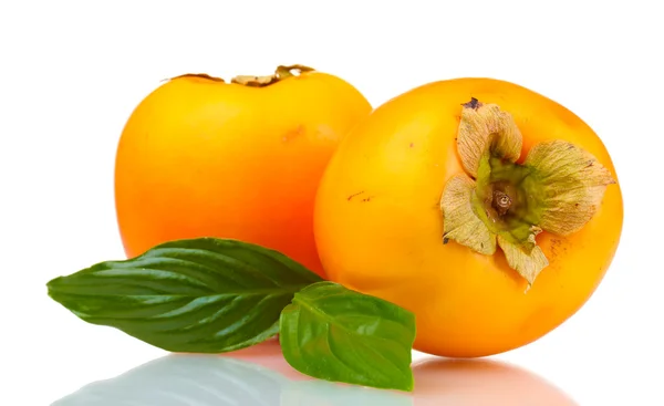 Two appetizing persimmons with green leaves isolated on white — Stock Photo, Image